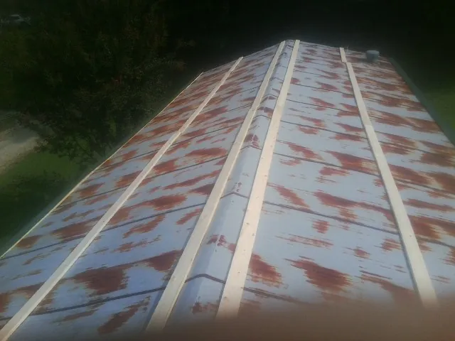 Rusted metal roof panels with new wood purlins before replacement — Storm Damage Roof Repair in Sonyea by Roofing Brothers
