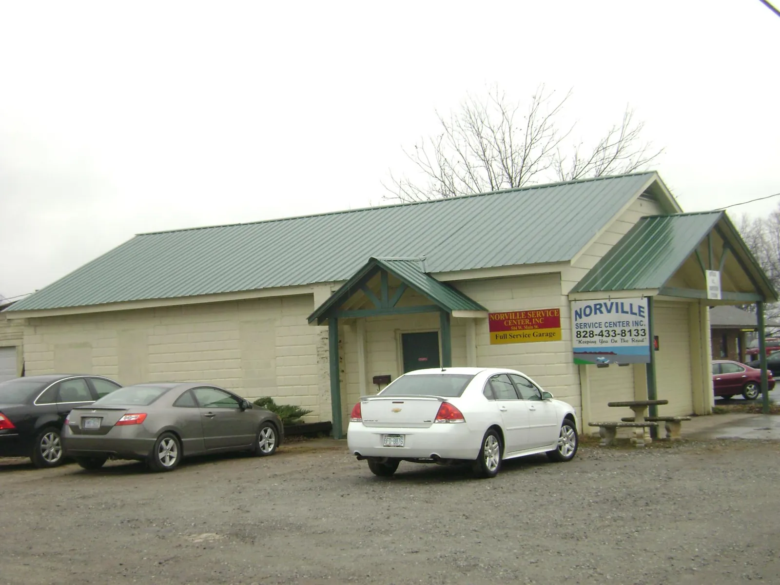 Green metal roof on a service garage with a covered entry in Sonyea